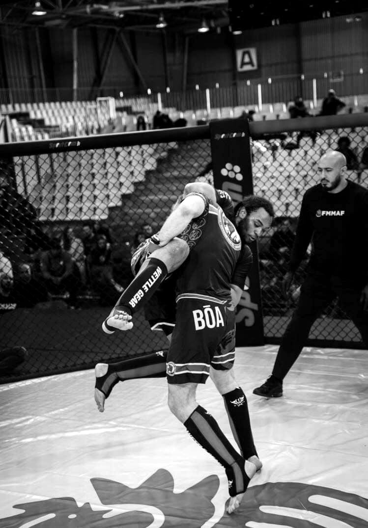 Combat de MMA amateur en cage, travail de percussion